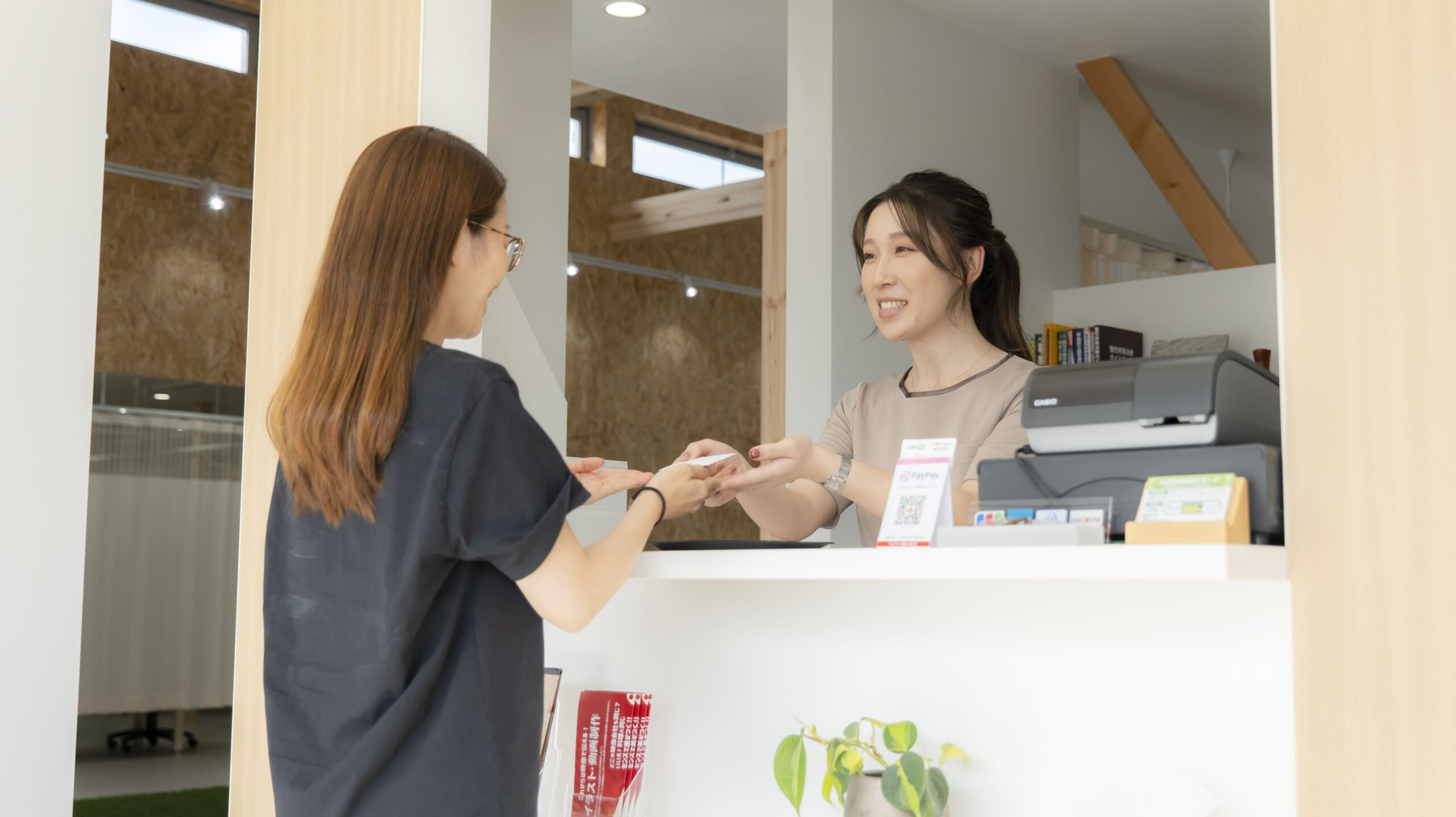 本沢整骨院の受付で交通事故の併用・転院について相談する様子